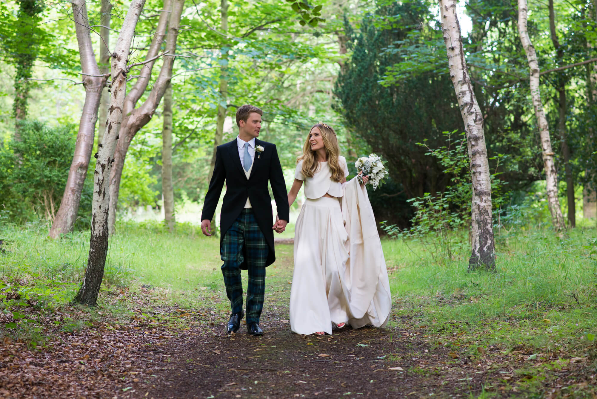 A bride and groom walking in the woods at Gosford House wedding in Scotland by Especially Amy wedding photography